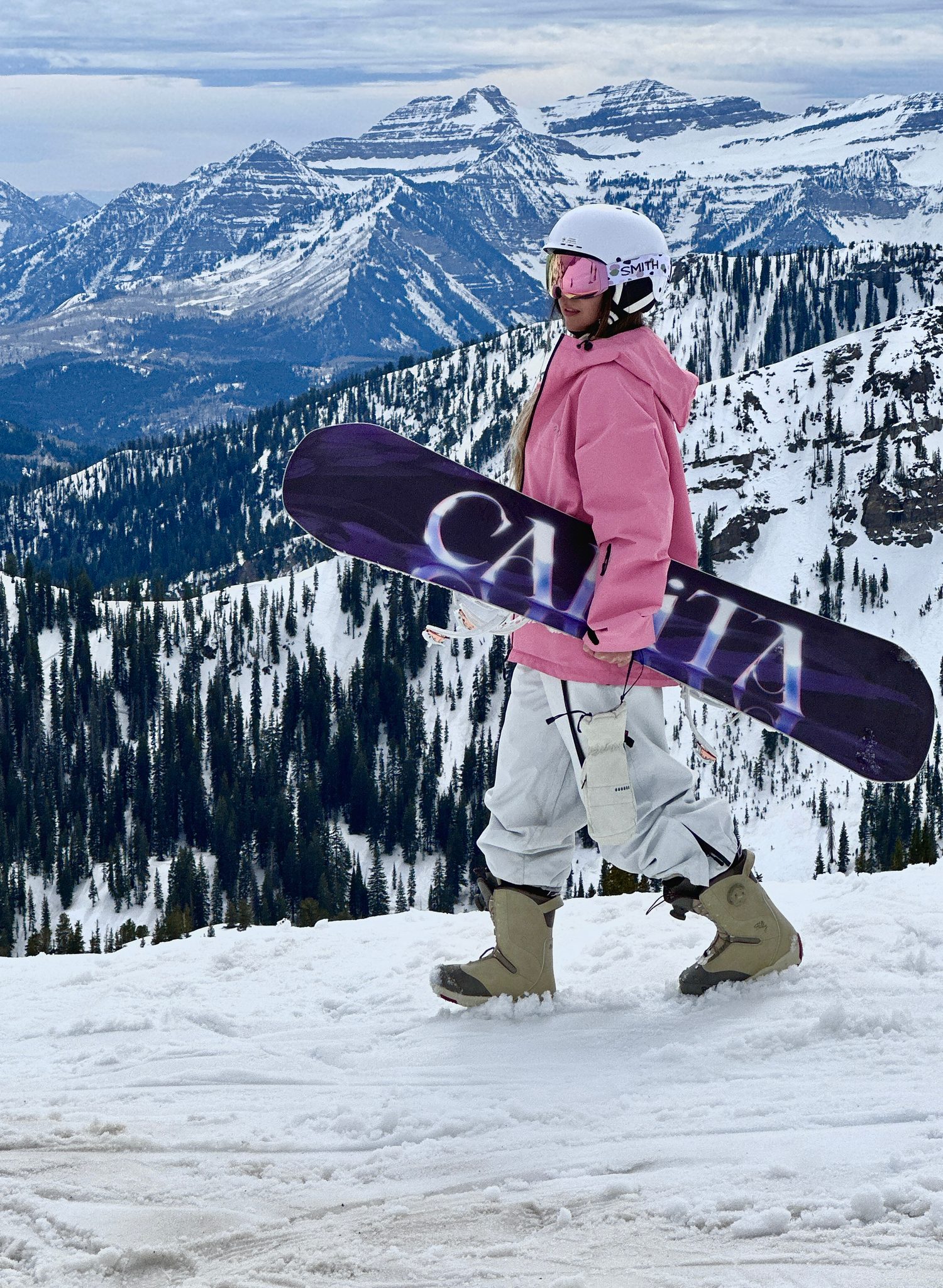 Freya holding a snowboard in the mountains